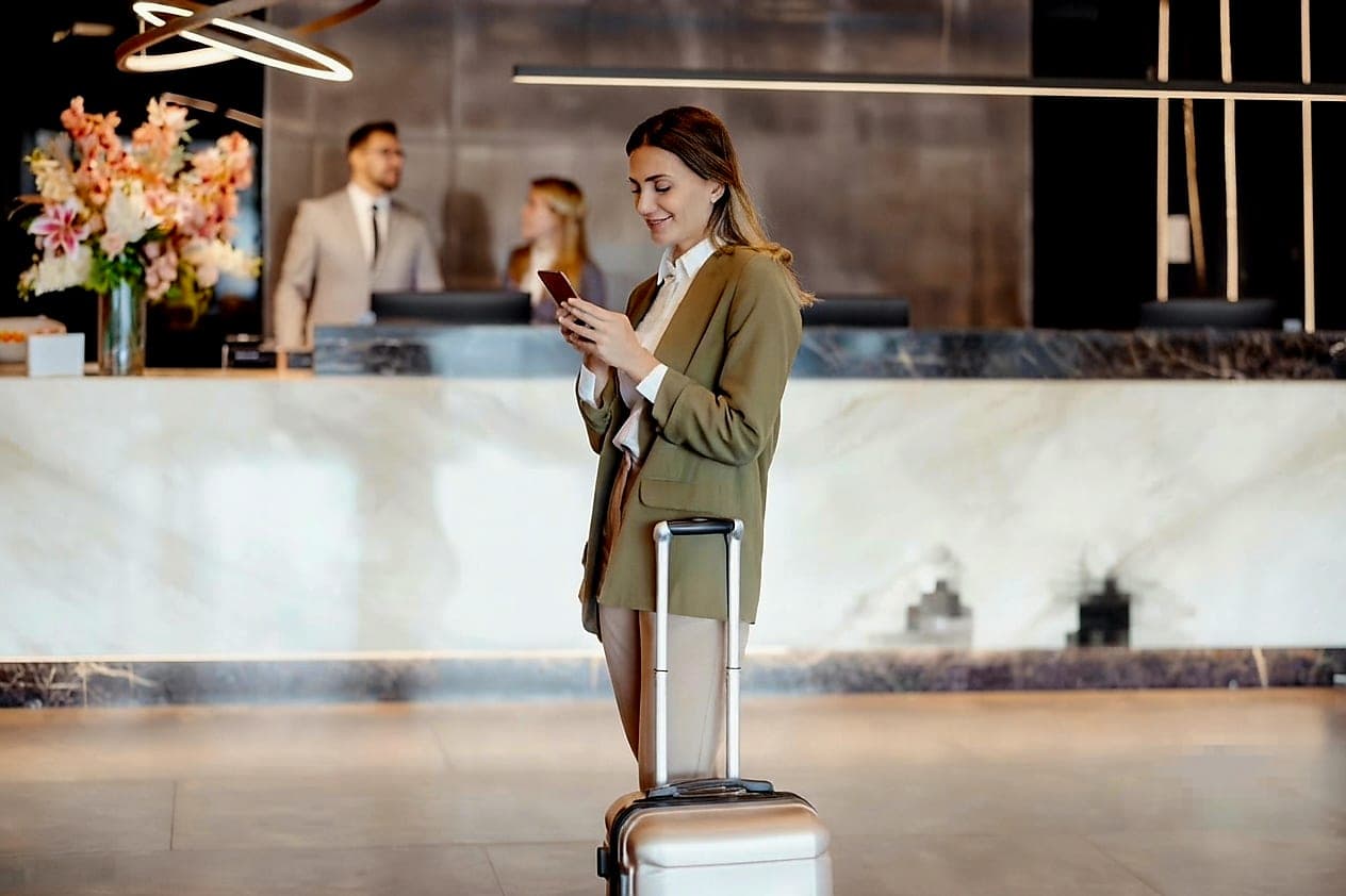 Ospite con lo smartphone alla reception di un hotel